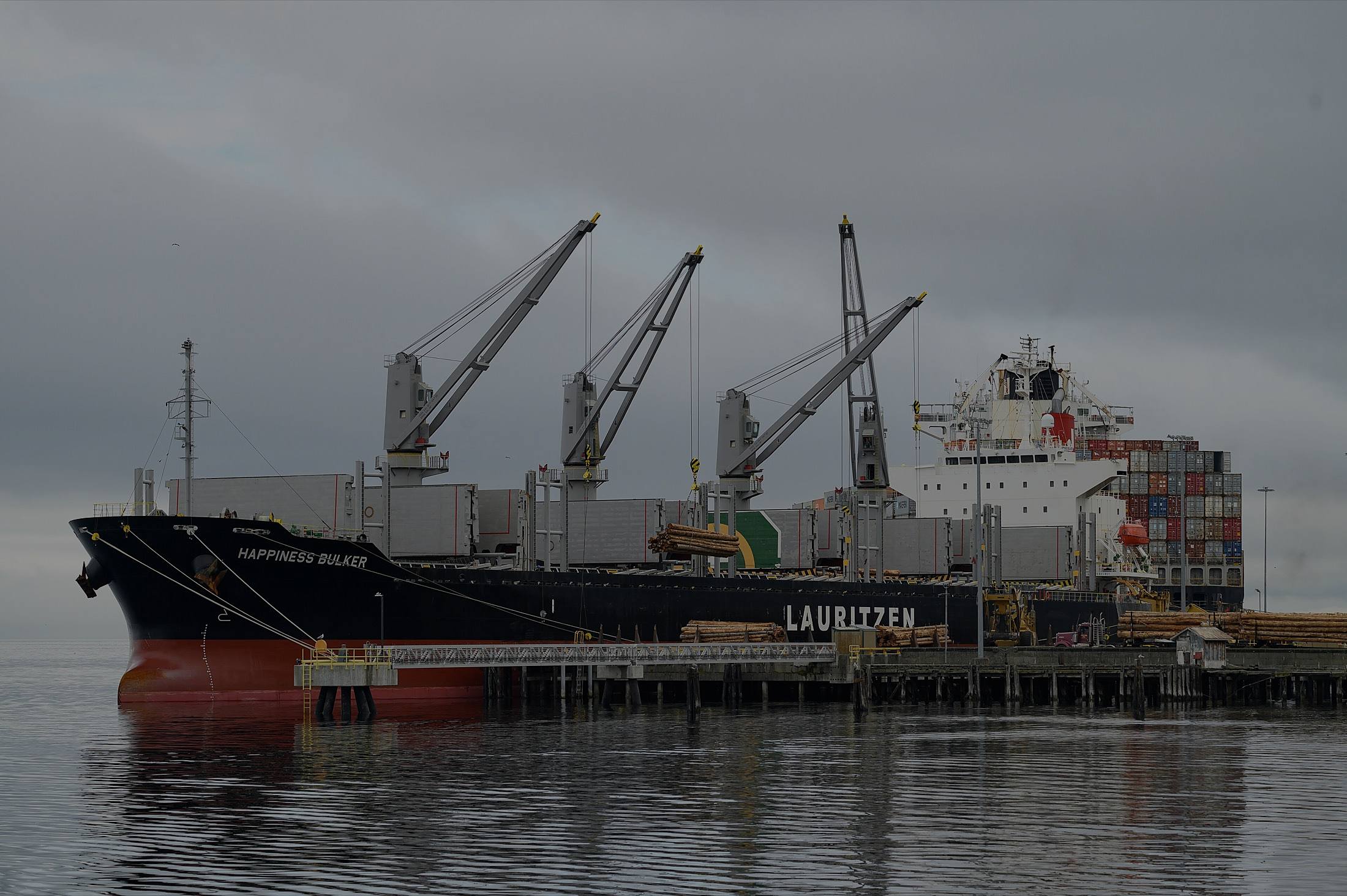 A dry-bulk carrier lying alongside a working terminal.